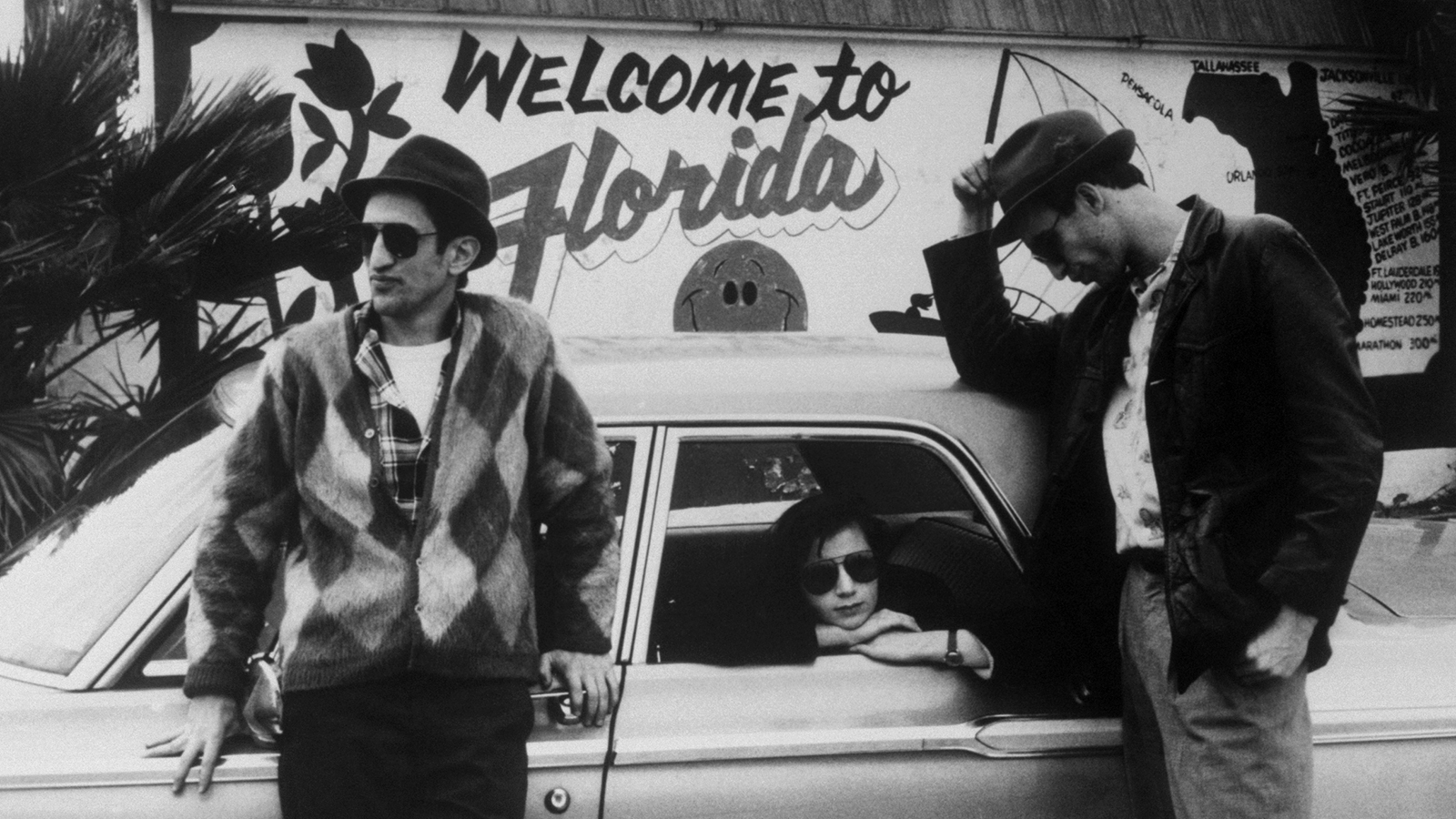 Scene from Stranger Than Paradise — three friends in front of Welcome to Florida sign