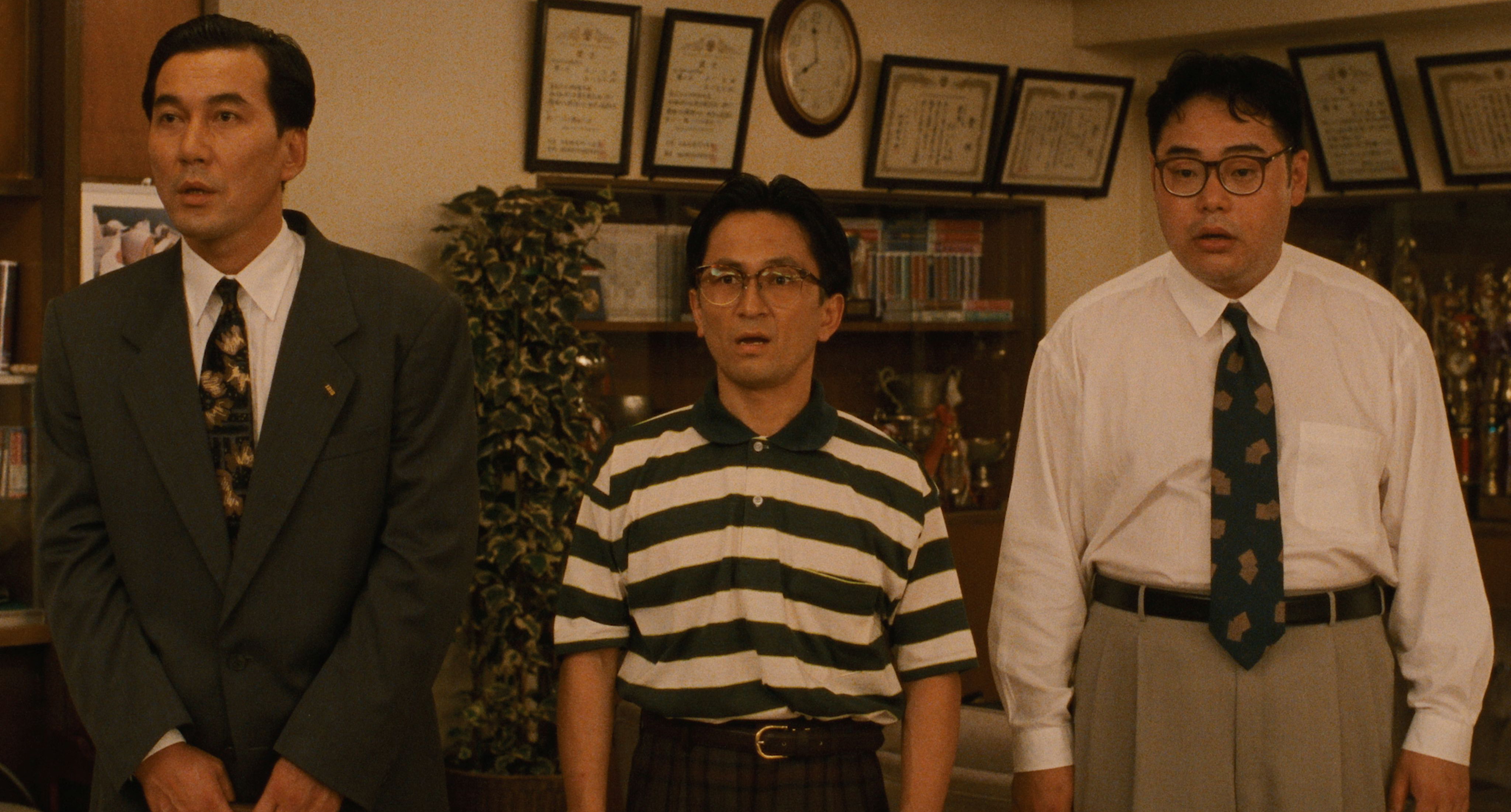 Three amateur dancers stand wide-eyed in the dance-studio lounge in Shall We Dance? (1996)