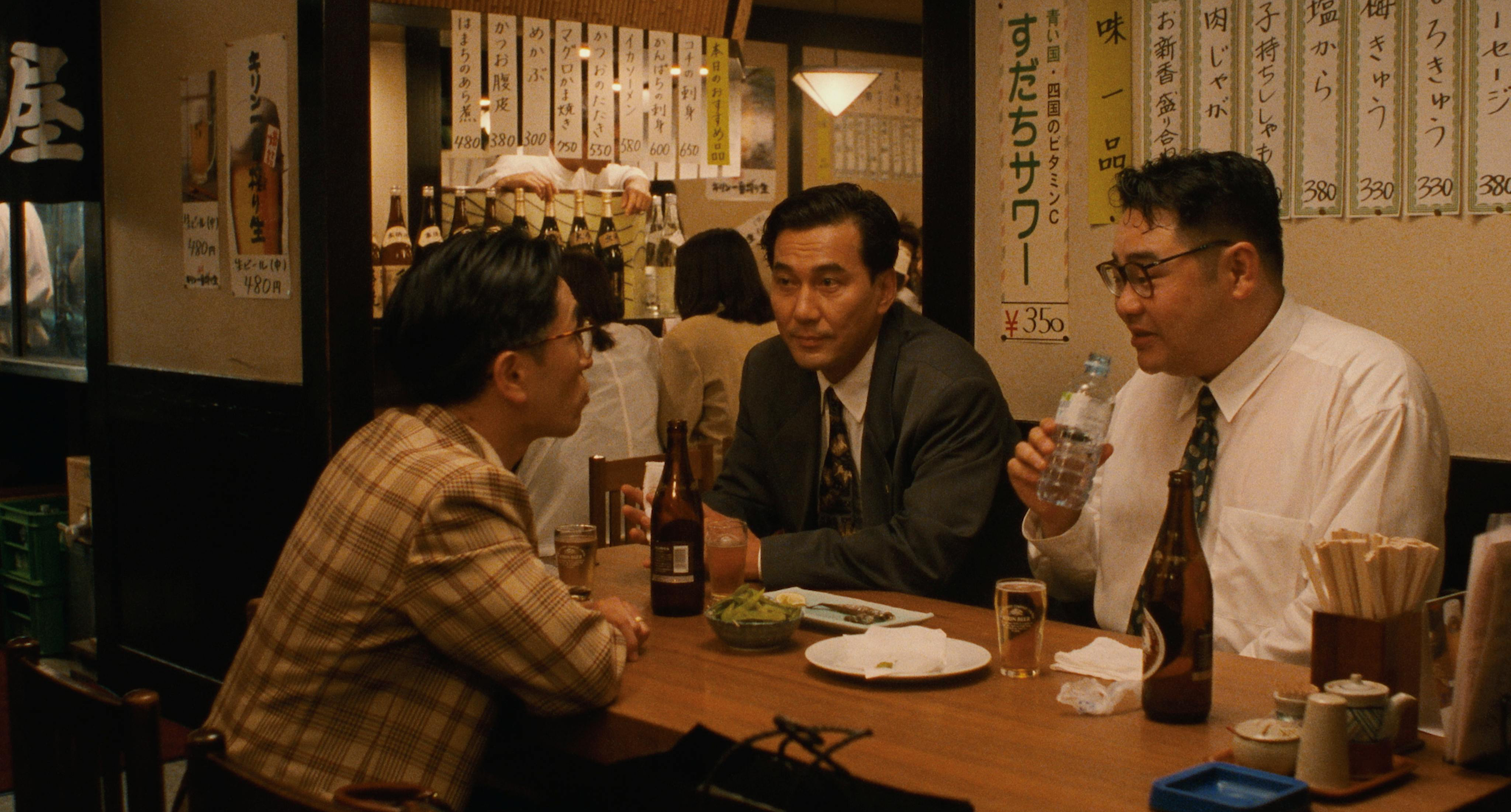 Three men talk over beers in a Tokyo izakaya in Shall We Dance? (1996)