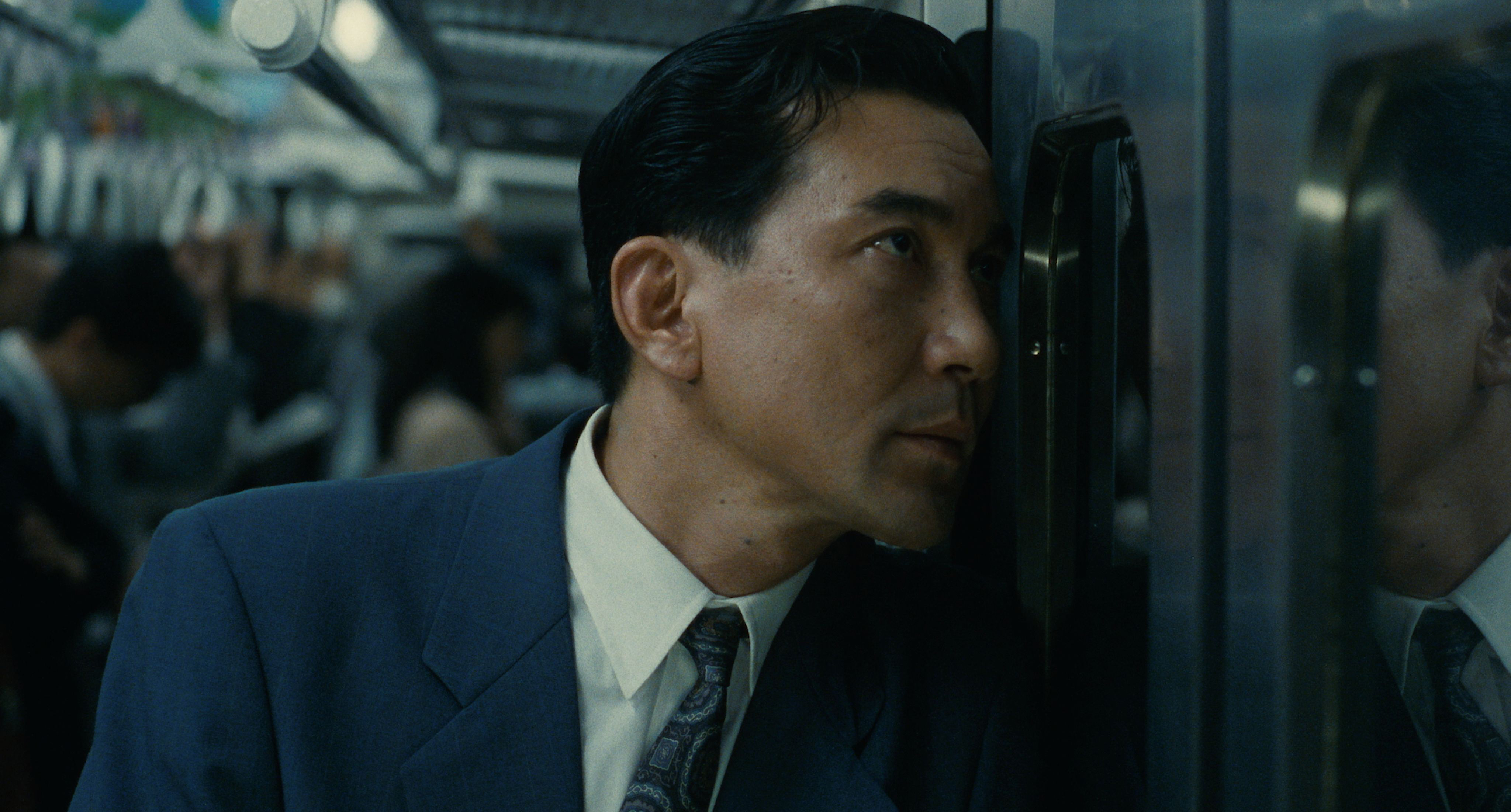 Koji Yakusho as Sugiyama rests his head against the train door at night in Shall We Dance? (1996)