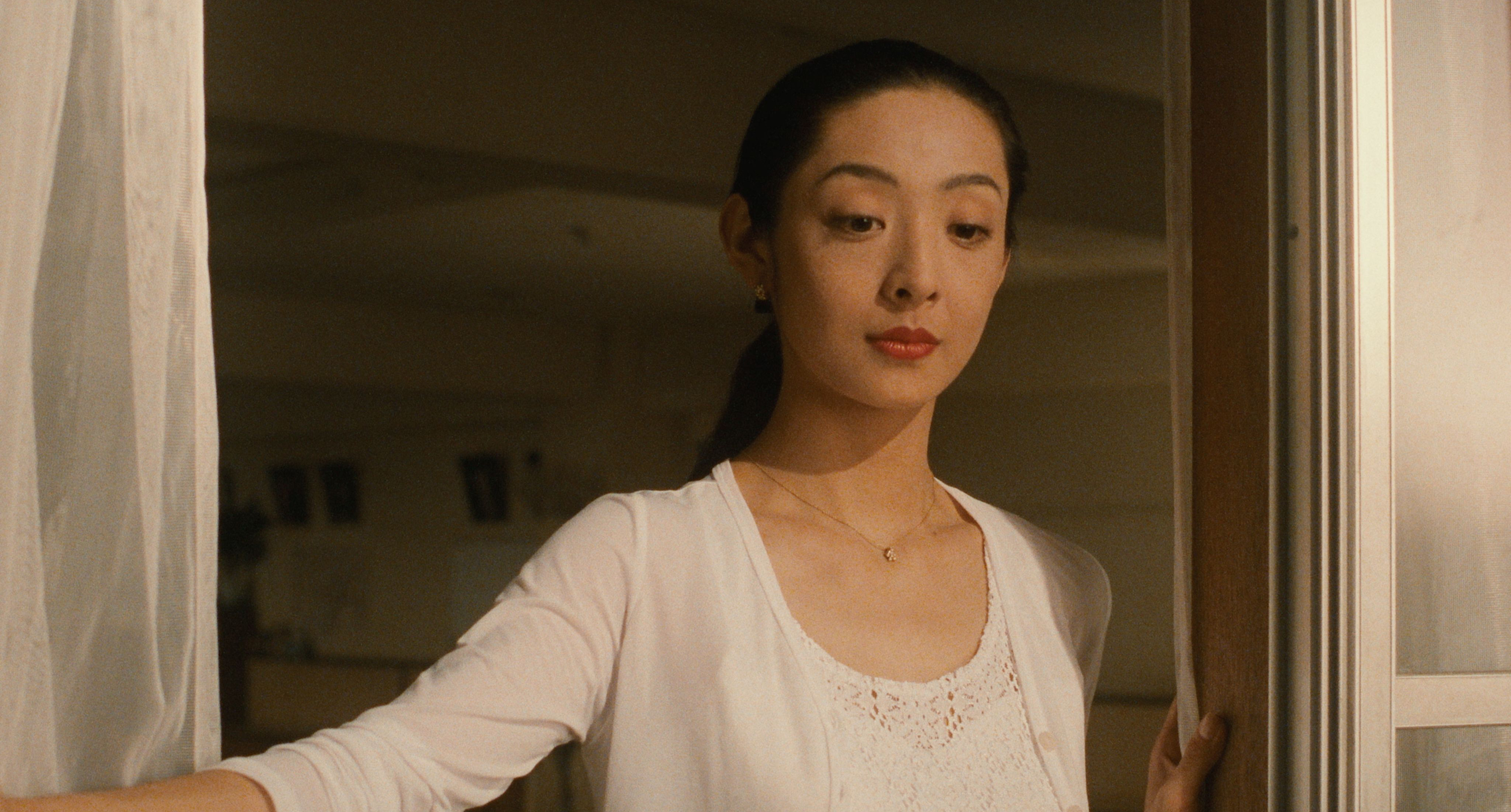 Tamiyo Kusakari as Mai Kishikawa stands pensively at a window in soft evening light in Shall We Dance? (1996)