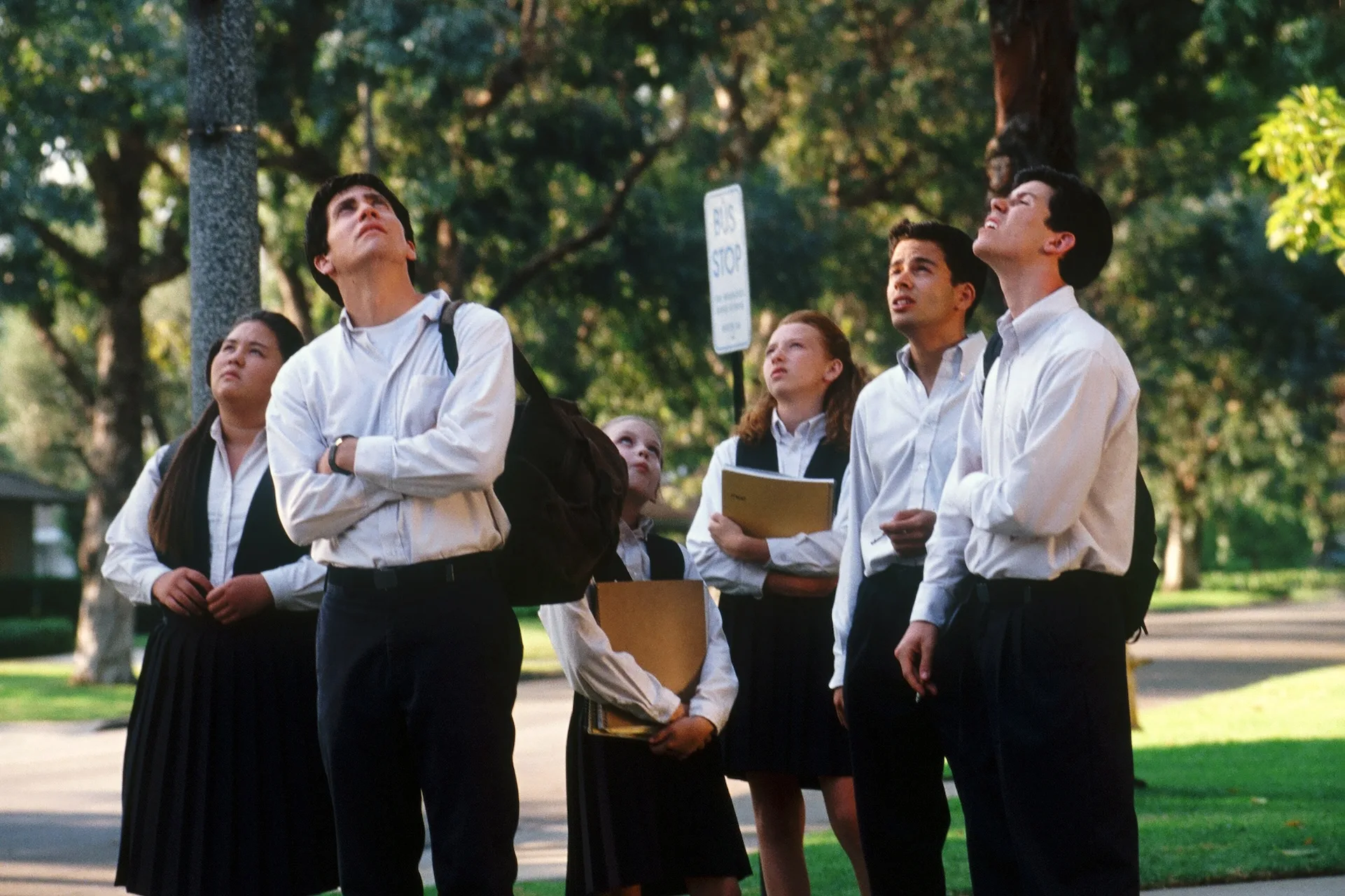 Jake Gyllenhaal as Donnie and his classmates look up at the sky at a suburban bus stop in Donnie Darko (2001)