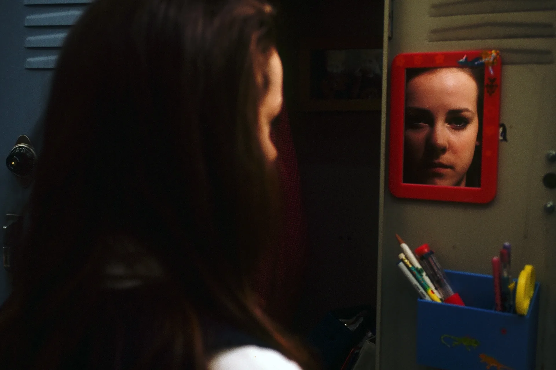 Jena Malone as Gretchen studies her reflection in a locker mirror in Donnie Darko (2001)