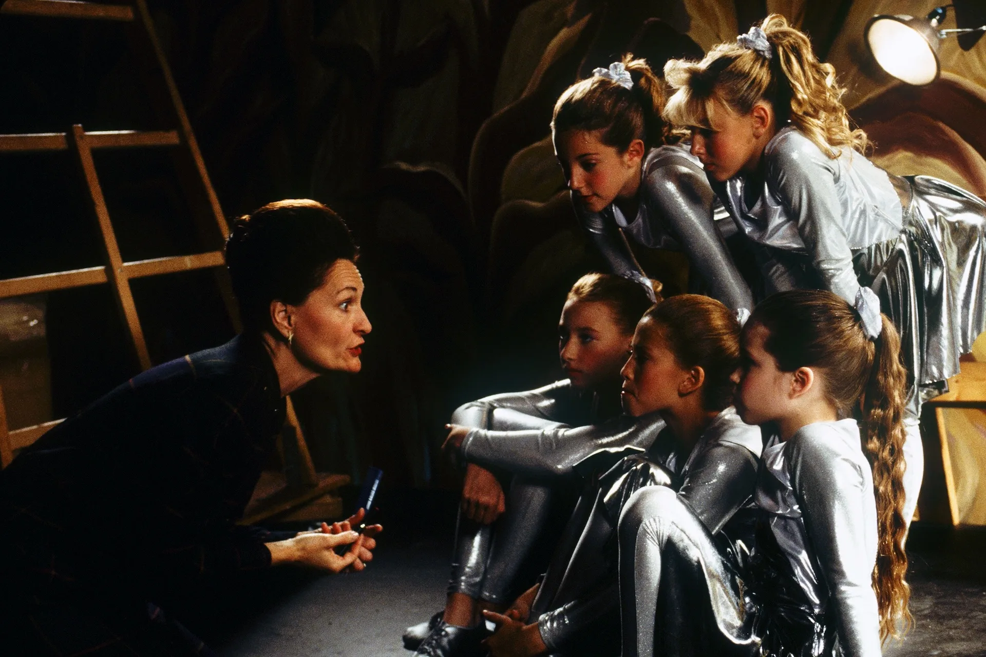 A dance coach instructs the young Sparkle Motion troupe in silver costumes in Donnie Darko (2001)