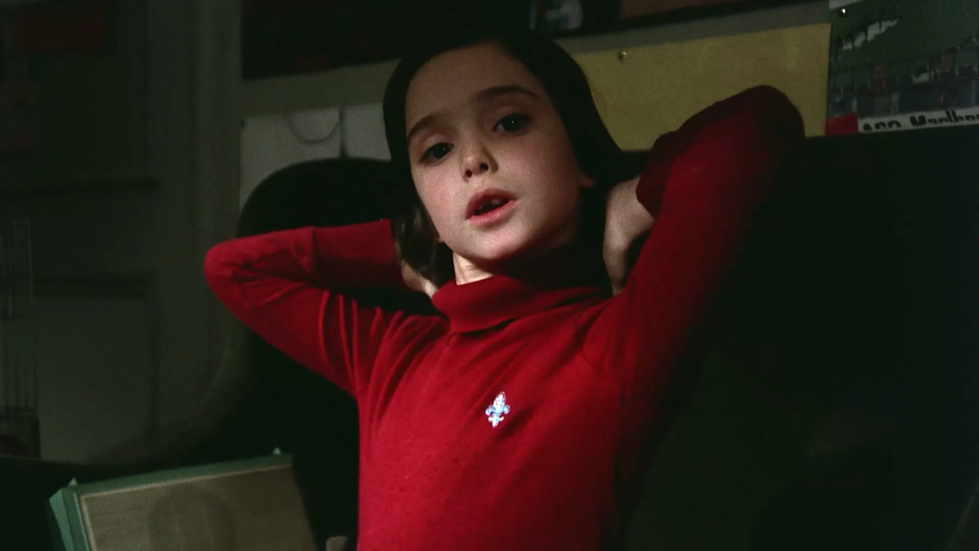 Ana Torrent leans back with arms behind her head in her bedroom in Cría Cuervos