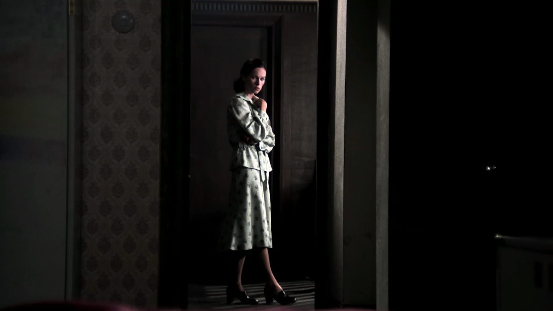 Ana's mother (Geraldine Chaplin) stands illuminated in a dark hallway in Cría Cuervos