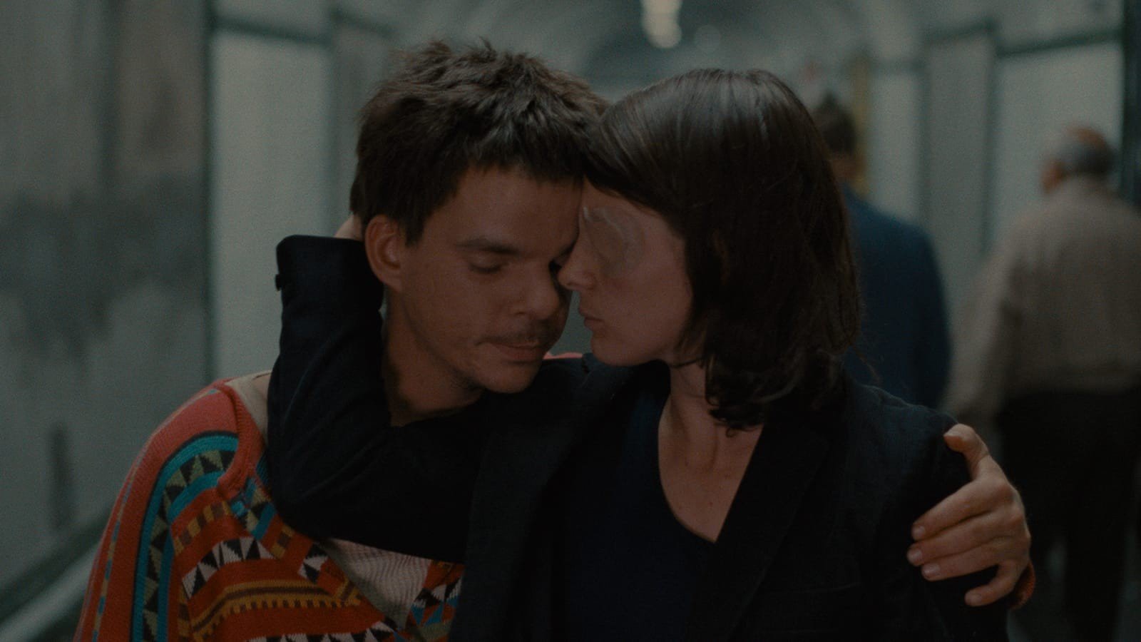 Denis Lavant as Alex rests his head against Juliette Binoche as Michèle, a patch over one eye, in a tiled underground corridor in Les Amants du Pont-Neuf (1991)